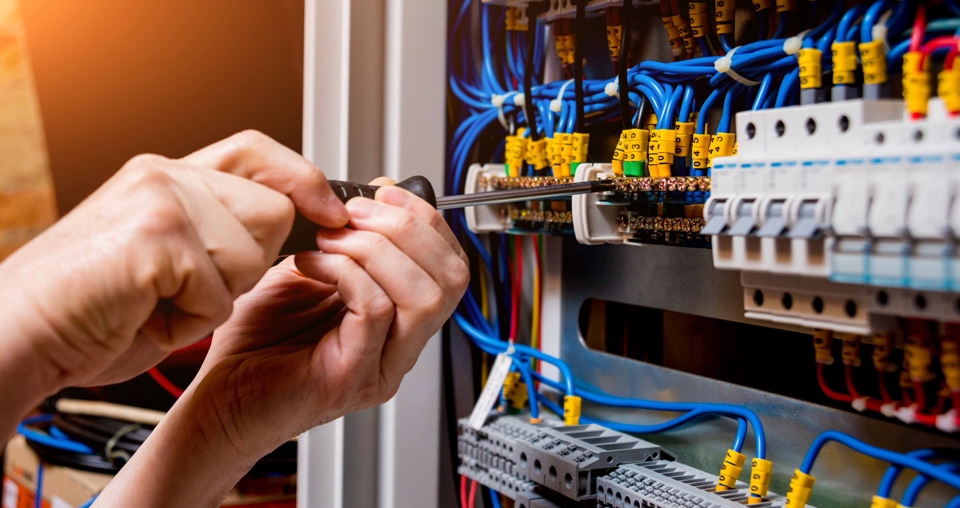 The man is repairing the switchboard voltage with automatic switches. Electrical background